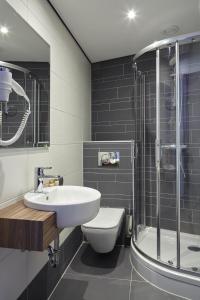 ein Bad mit einem Waschbecken, einem WC und einer Dusche in der Unterkunft The Muse Amsterdam - Boutique Hotel in Amsterdam