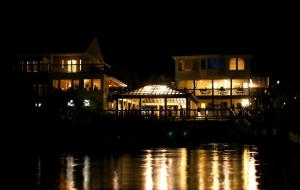 a lit up building at night next to a body of water at The Inn on Pamlico Sound in Buxton