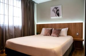 um quarto com uma cama grande com janela em SkyHub em Bogotá