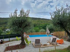 a swimming pool in a yard with chairs and a tree at Moinho de Palma de NaturAlegre in Alegrete