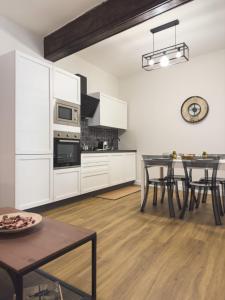 a kitchen with white cabinets and a dining table at Dimora Aimonetto in Pinerolo