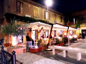 ein Restaurant mit weißen Sonnenschirmen in der Nacht auf einer Straße in der Unterkunft Domus Tepula II in Rom + 13 Fotos