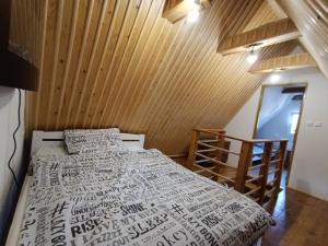 a bedroom with a bed and a wooden wall at Agroturystyka Skała i Las - Noclegi Beskid Niski in Nowy Żmigród +16 photos