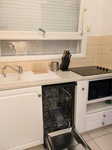 a kitchen with a dishwasher in the middle of a sink at Cannes Studio near Croisette Plage in Cannes