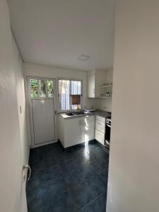 a kitchen with white cabinets and a tile floor at Casi en Casa 2 in Lincoln