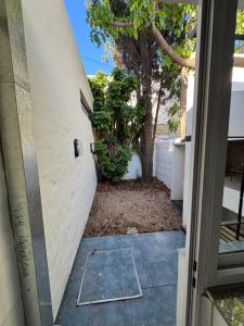 a door leading into a courtyard with a tree at Casi en Casa 2 in Lincoln
