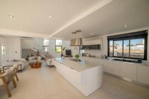 d'une cuisine et d'un salon avec des placards blancs et une table. dans l'établissement Villa Rizo de luxe, à Flic-en-Flac