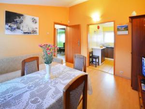 a dining room with a table with a vase of flowers on it at Holiday Home in Rosnowo by Lake Rosnowskie in Rosnowo