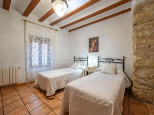 1 Schlafzimmer mit 2 Betten und einer Steinmauer in der Unterkunft Premium cottage with swimming pool in Hoya-Gonzalo