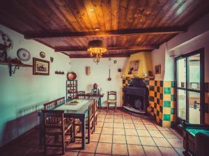 ein Wohnzimmer mit Tisch und Stühlen und einem Kamin in der Unterkunft Appealing cottage with hot tub in Hoya-Gonzalo