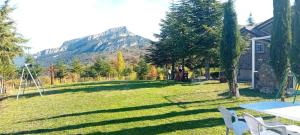 a yard with a table and chairs and a mountain at Chalet B&B parcodellatimpa in Civita