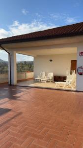 a patio with white chairs on top of a house at Casa Vacanze Cerreto 3 in Miglianico