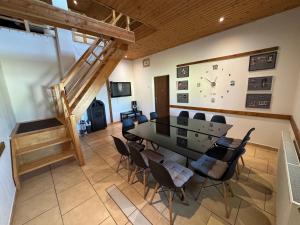 a dining room with a table and chairs and a clock at Chata Cerovo in Cerovo