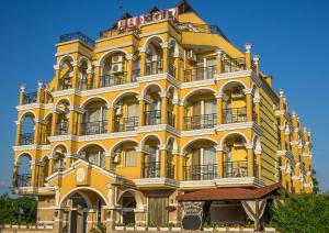 un edificio giallo con balconi in cima di Hotel Luxor a Lozenets