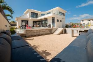 une grande maison blanche avec une grande arrière-cour dans l'établissement Villa Rizo de luxe, à Flic-en-Flac