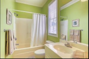 a green bathroom with a sink and a toilet at Bay Breeze - 3 Min Walk to Beach in Tybee Island
