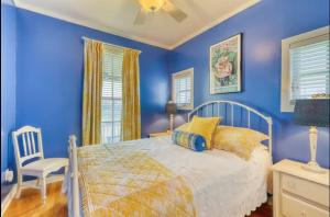 a blue bedroom with a bed and a chair at Bay Breeze - 3 Min Walk to Beach in Tybee Island