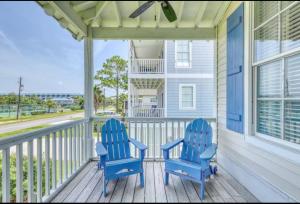 two blue chairs sitting on the front porch of a house at Bay Breeze - 3 Min Walk to Beach in Tybee Island