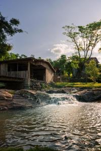 a building next to a river with a waterfall at Casa, sítio, aconchegante no Vale dos Vinhedos. in Bento Gonçalves +37 photos