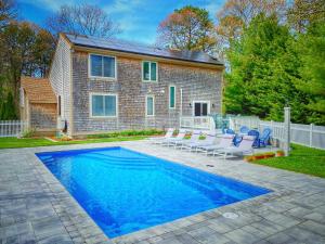 a house with a swimming pool in front of a house at Overlook Poolside Getaway With Seasonal Pool in Falmouth