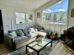 ein Wohnzimmer mit einer Couch und einem Glastisch in der Unterkunft Spacious 4BR Mountain View 5 min to PC Resort in Park City