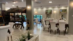 a person standing in a room with a table and chairs at Laguna Resort SPA in Augustów