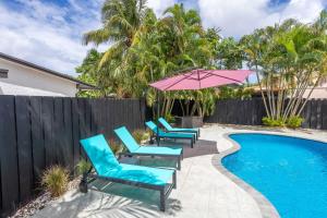 デルレイビーチにあるDazzling Delrayのスイミングプールの隣にパティオ(椅子、パラソル付)