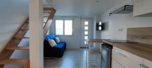 a living room with a blue couch and a staircase at Studio climatisé dans une propriété calme in Digne-les-Bains