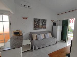 a living room with a couch and a refrigerator at private Bungalow next to Yumbo Center in Playa del Ingles