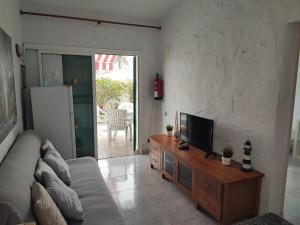 a living room with a couch and a flat screen tv at private Bungalow next to Yumbo Center in Playa del Ingles