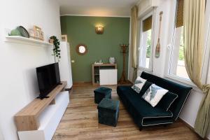 a living room with a couch and a tv at 5 mins to the beach, cozy home in Rapallo