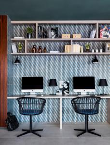 een bureau met 2 monitoren en 2 stoelen in een kamer bij Okko Hotels Cannes Centre in Cannes