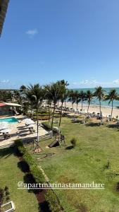 a view of a beach with palm trees and the ocean at Apart Hotel Marinas Tamandaré in Tamandaré