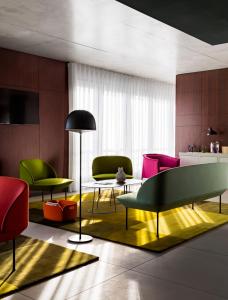 uma sala de estar com cadeiras coloridas e uma mesa em Okko Hotels Cannes Centre em Cannes