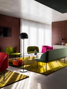 a living room with colorful chairs and a table at OKKO Hotels Cannes Centre in Cannes