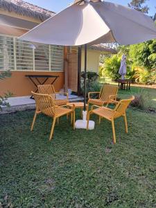 een groep stoelen en een paraplu op een tuin bij Le Bunga'Zen in Grand-Bourg