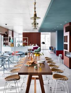 a dining room with a large wooden table and chairs at Okko Hotels Cannes Centre in Cannes