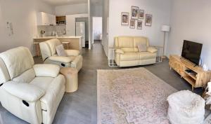 a living room with two white couches and a tv at Location, location, location - ground floor in Brisbane