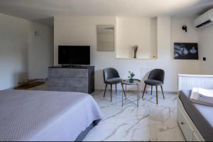 a bedroom with a bed and two chairs and a television at Bea's Room in Nocera Inferiore