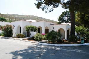 een wit gebouw met bomen en bloemen in een straat bij Villaggio Turistico Valle Scinni in Peschici
