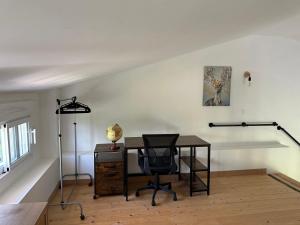ein Büro mit einem Schreibtisch und einem Stuhl in einem Raum in der Unterkunft La Cabane de Nina, cottage chaleureux in Plassac