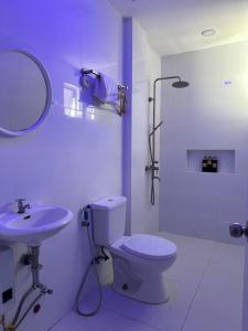a white bathroom with a toilet and a sink at Casa Rama Hotel Tagaytay in Tagaytay +57 photos