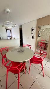uma sala de jantar com uma mesa e cadeiras vermelhas em DN Apartamento no beach class ,VISTA MAR ,Fortaleza em Fortaleza mais 40 fotografias