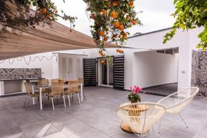 an outdoor patio with a table and chairs at Oasi Agrumi e Mare in Mascali