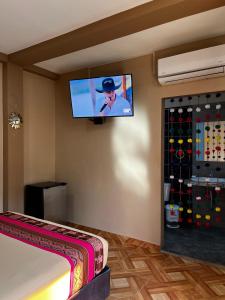 a room with a flat screen tv on the wall at Machu Picchu Selva Hotel in Isla Chinería