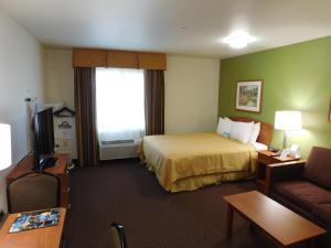 A bed or beds in a room at Days Inn & Suites by Wyndham Rochester South