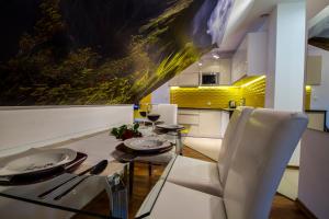 a dining room with a glass table and white chairs at Katmandu in Zakopane