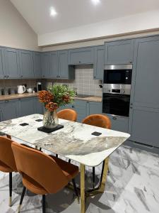 a kitchen with a table with a vase of flowers on it at The Cleveland Retreat - sauna stay in Boosbeck