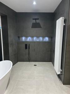 a bathroom with a tub and a sink and a bath tub at The Cleveland Retreat - sauna stay in Boosbeck