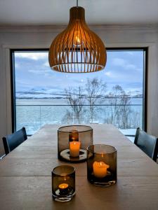 a dining room table with candles and a chandelier at Hus med egen strandlinje in Tromsø